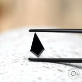 Kite shaped black moissanite with reflective surface close up