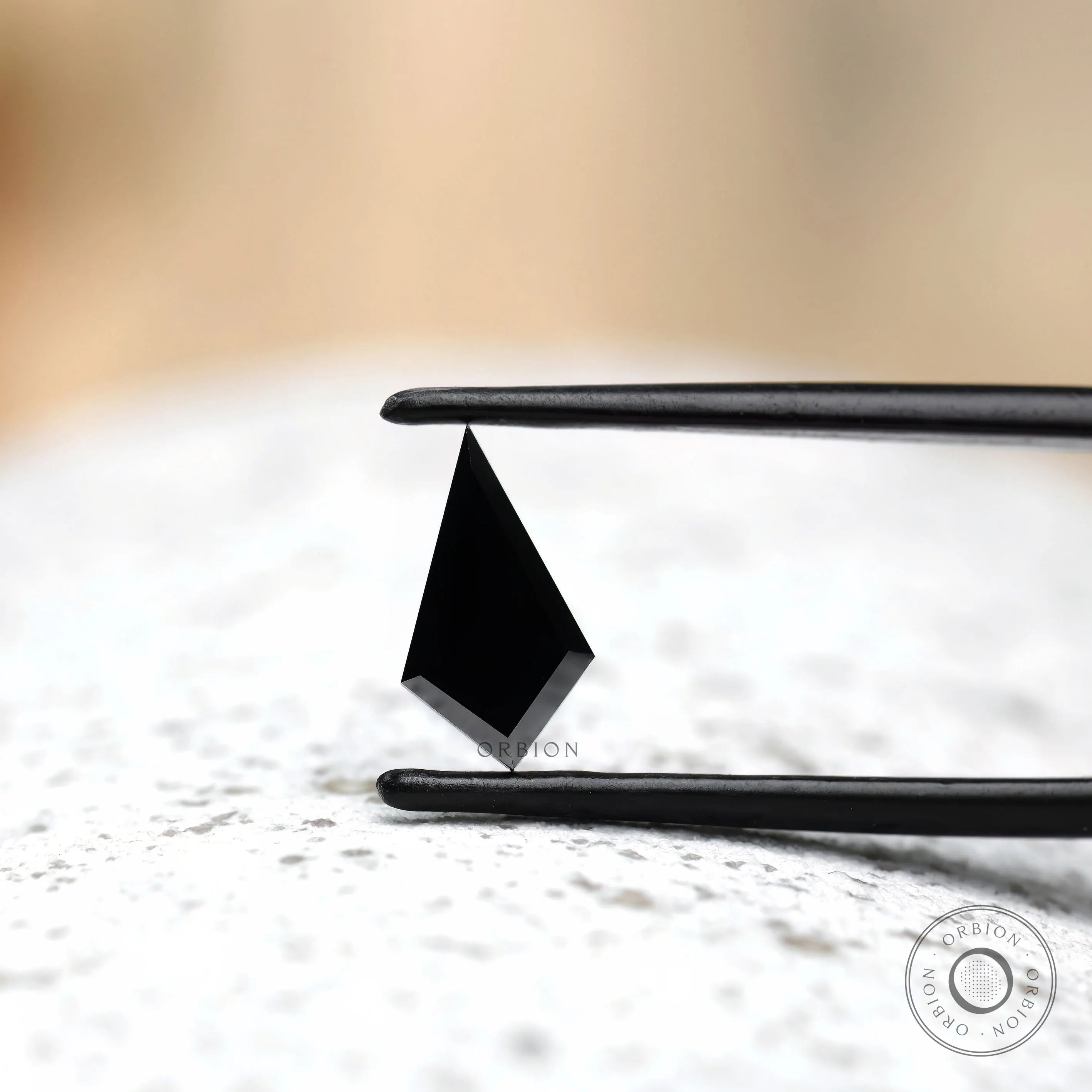 Kite shaped black moissanite with reflective surface close up