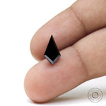 Loose kite moissanite displayed on fingertip for size reference
