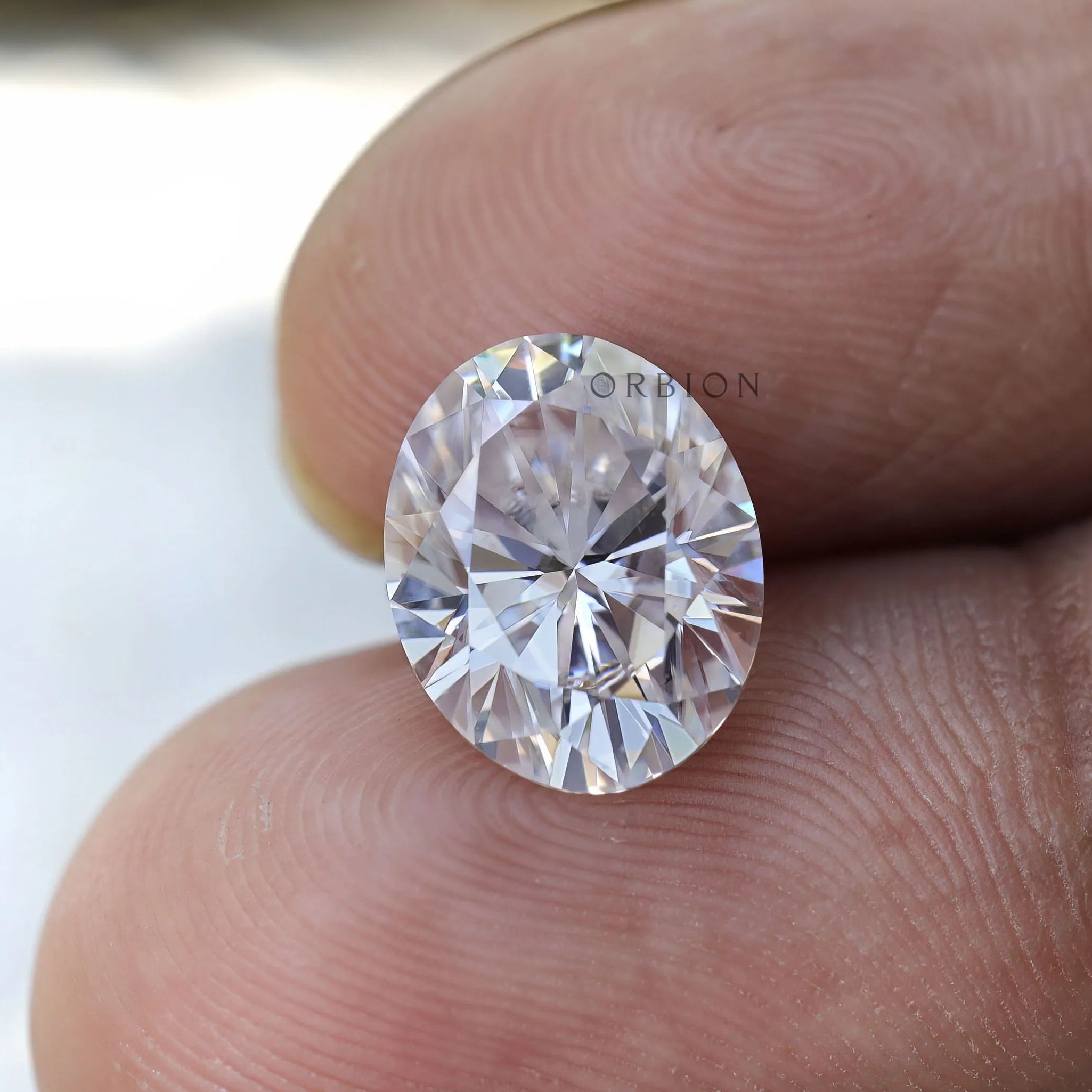 Oval cut moissanite on fingertip size reference