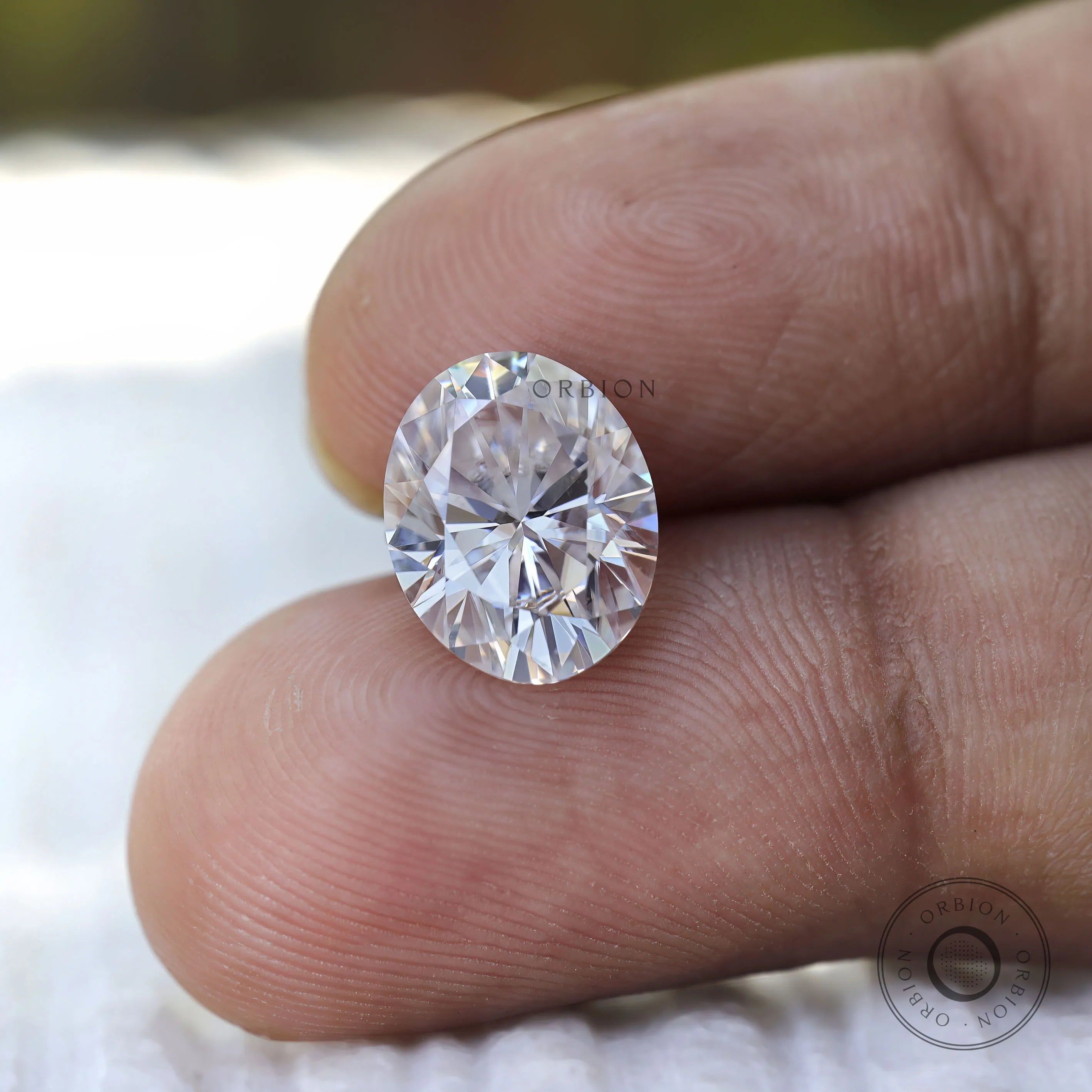 Oval cut moissanite on fingertip size reference