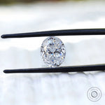 Oval crushed ice cut moissanite held with tweezers close view