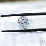 Oval crushed ice cut moissanite held with tweezers close view