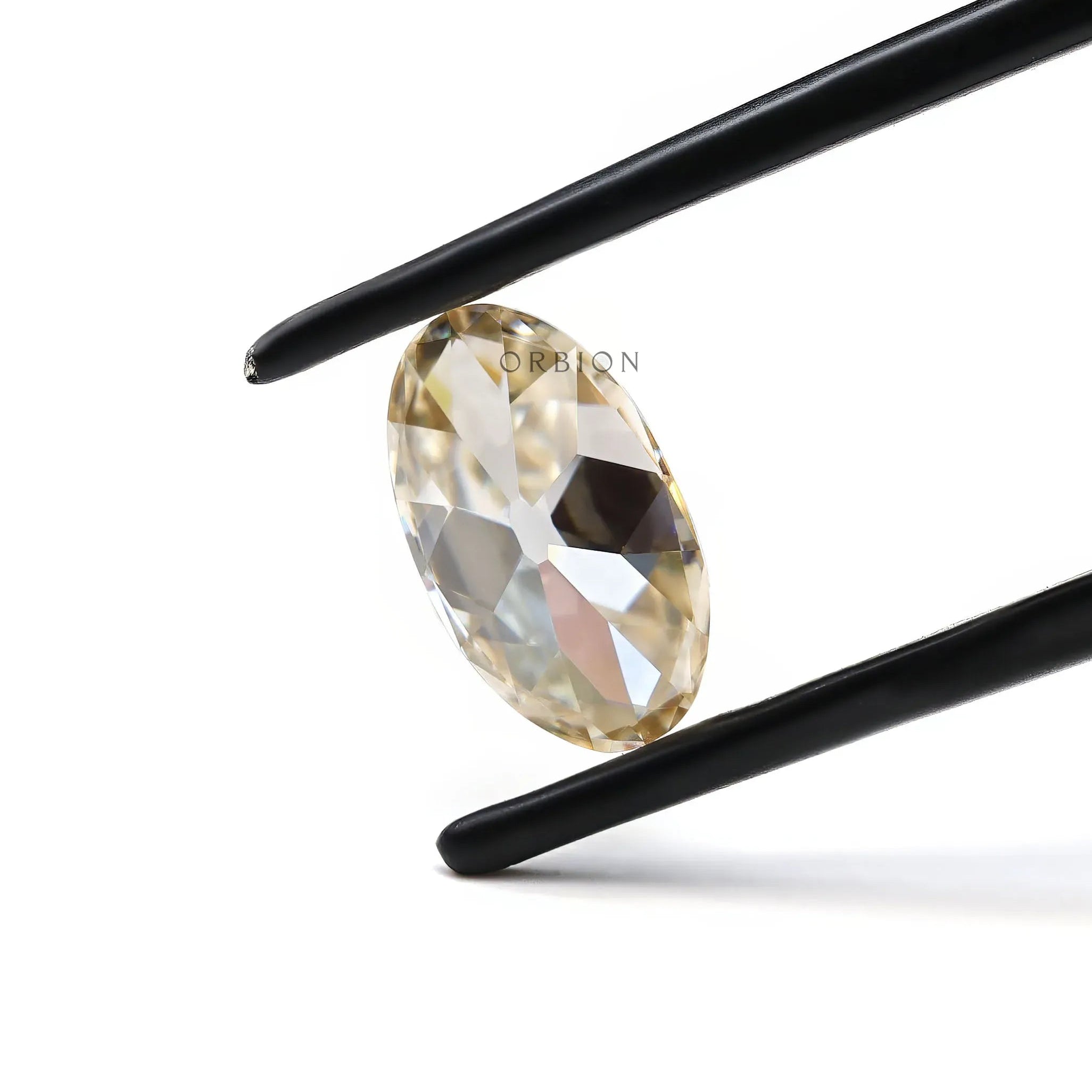 Elongated oval moissanite held in tweezers