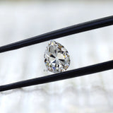 Front view of pear old mine cut moissanite in tweezers