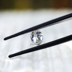 Side profile of pear moissanite on textured surface