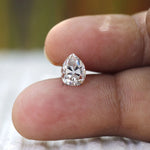 Close finger shot showing brilliance of pear moissanite