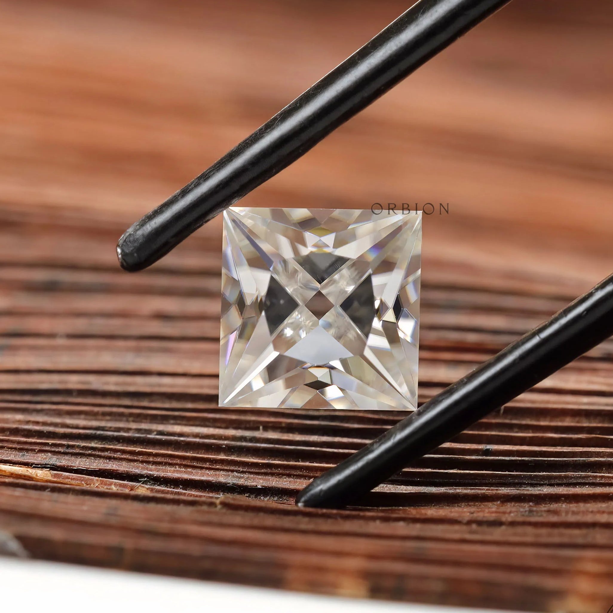 Loose princess moissanite stone on wooden background