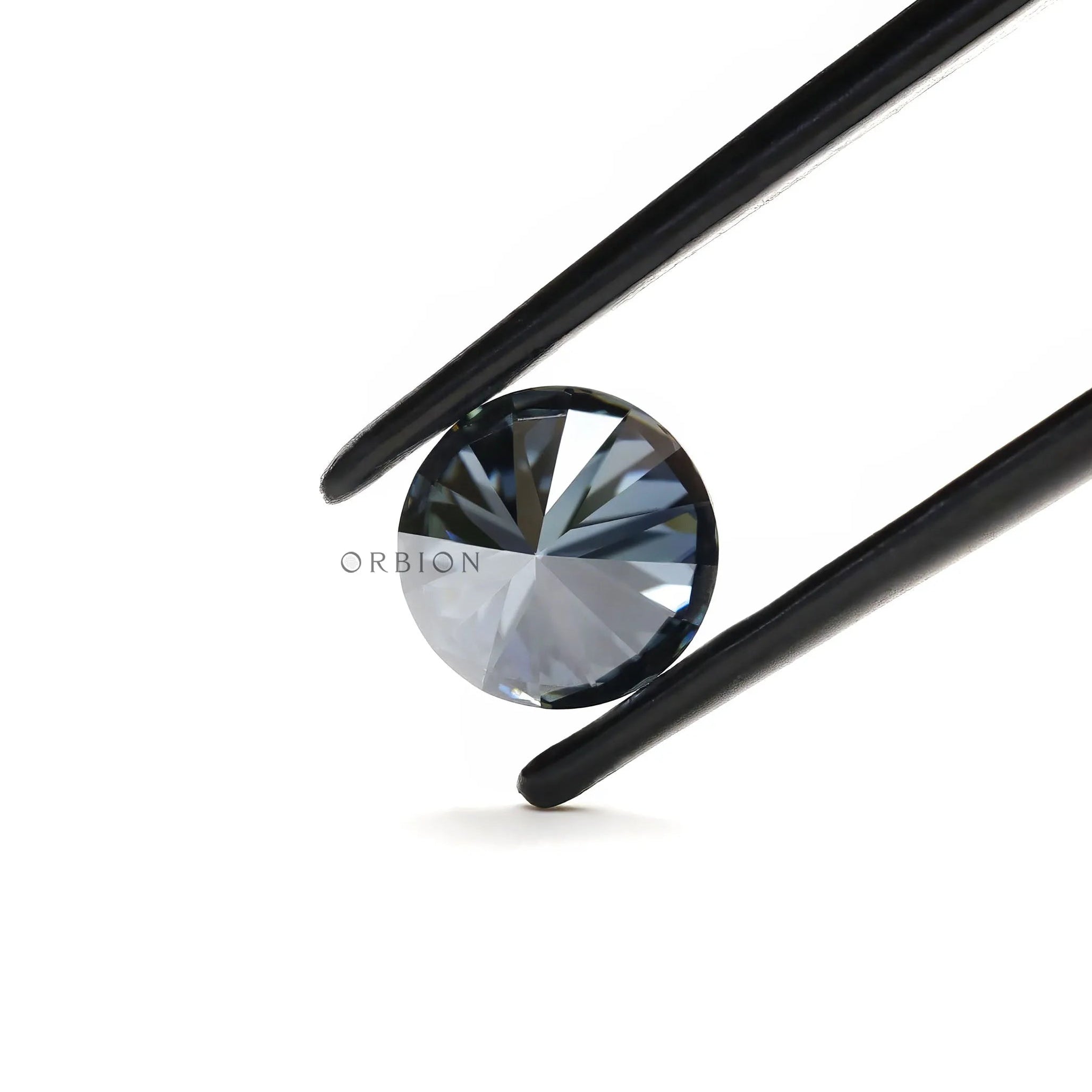 Close up of round dark grey moissanite with deep reflective brilliance