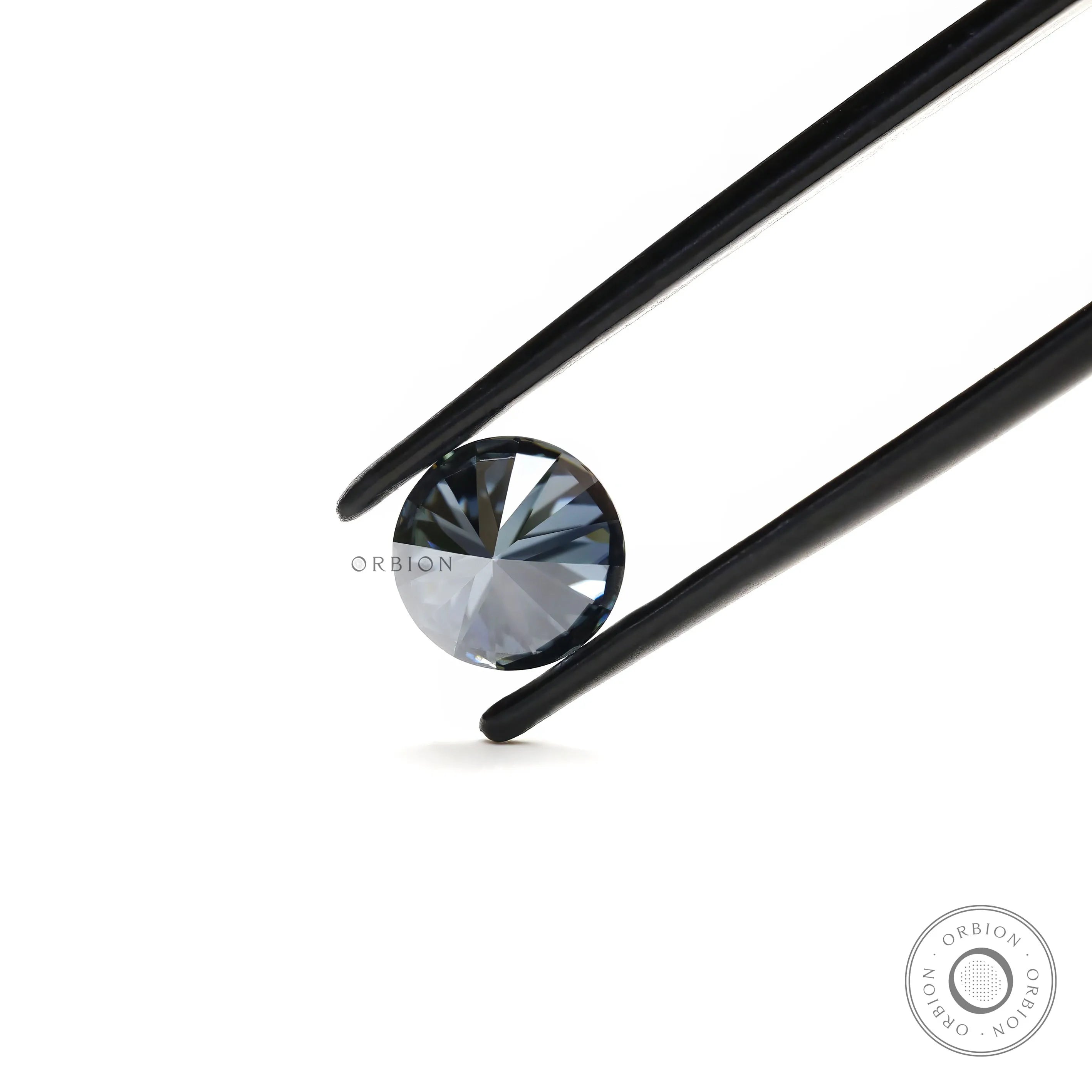 Close up of round dark grey moissanite with deep reflective brilliance
