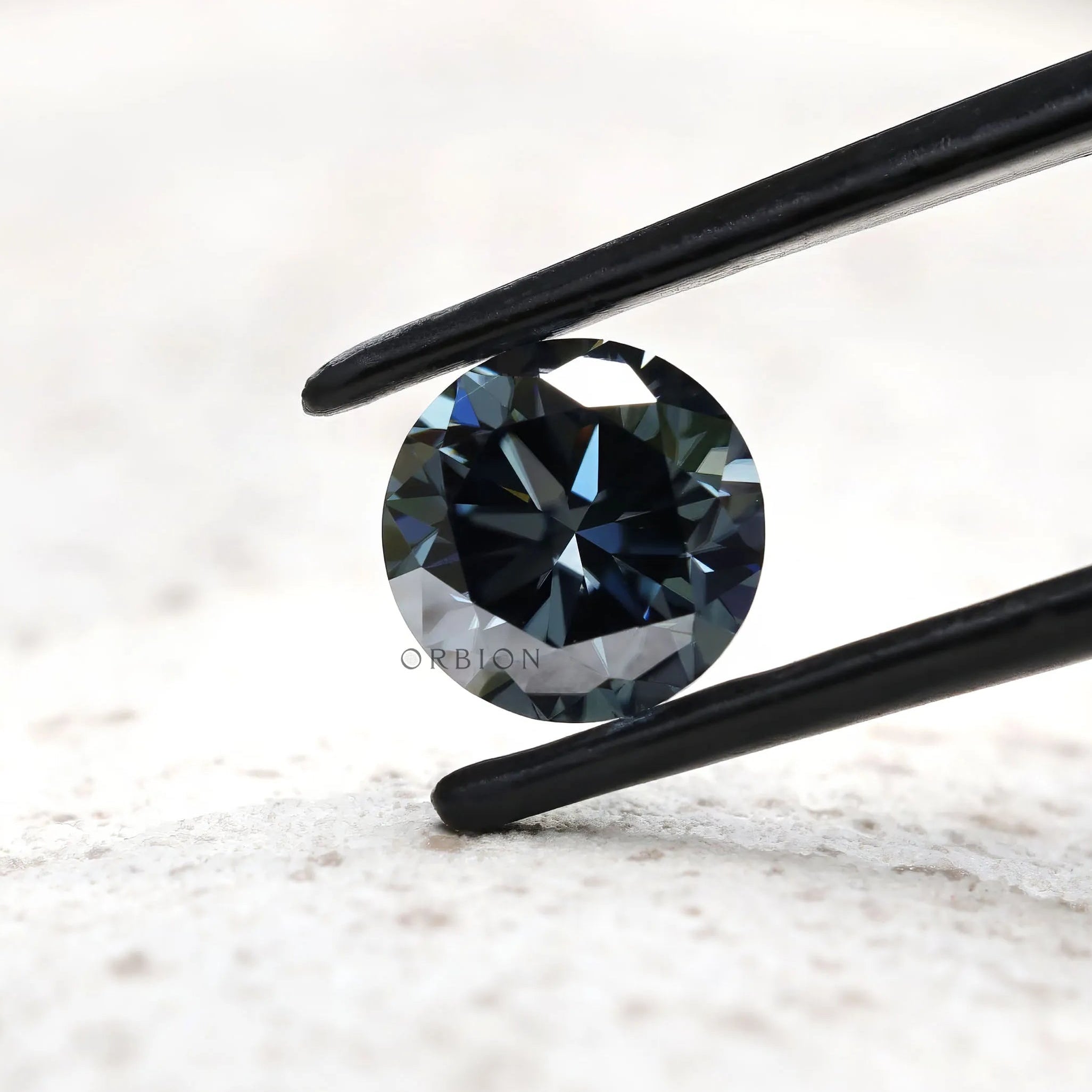 Dark grey moissanite round stone showing contrast of light and shadow