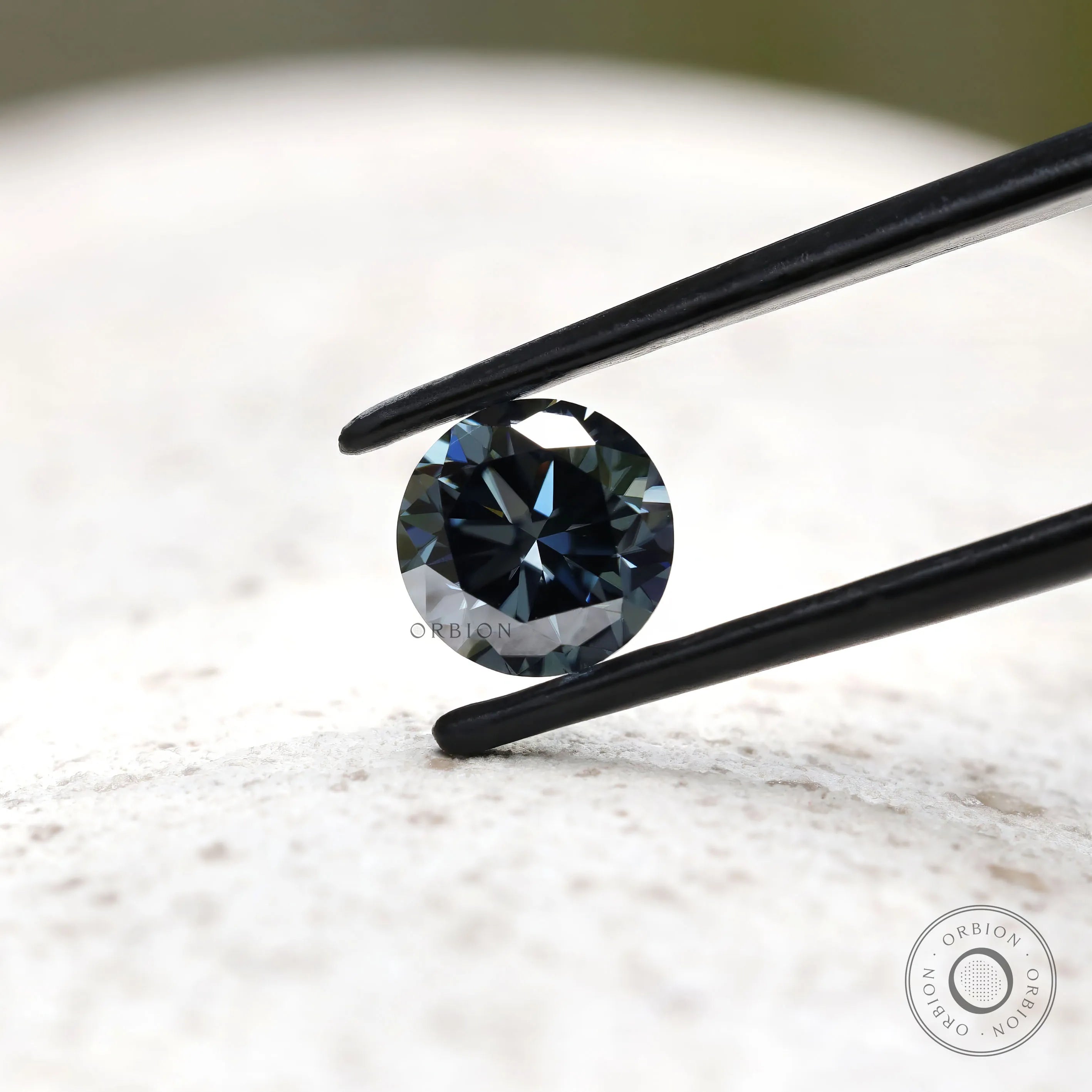 Dark grey moissanite round stone showing contrast of light and shadow