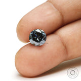Round brilliant cut dark grey moissanite gemstone placed on surface