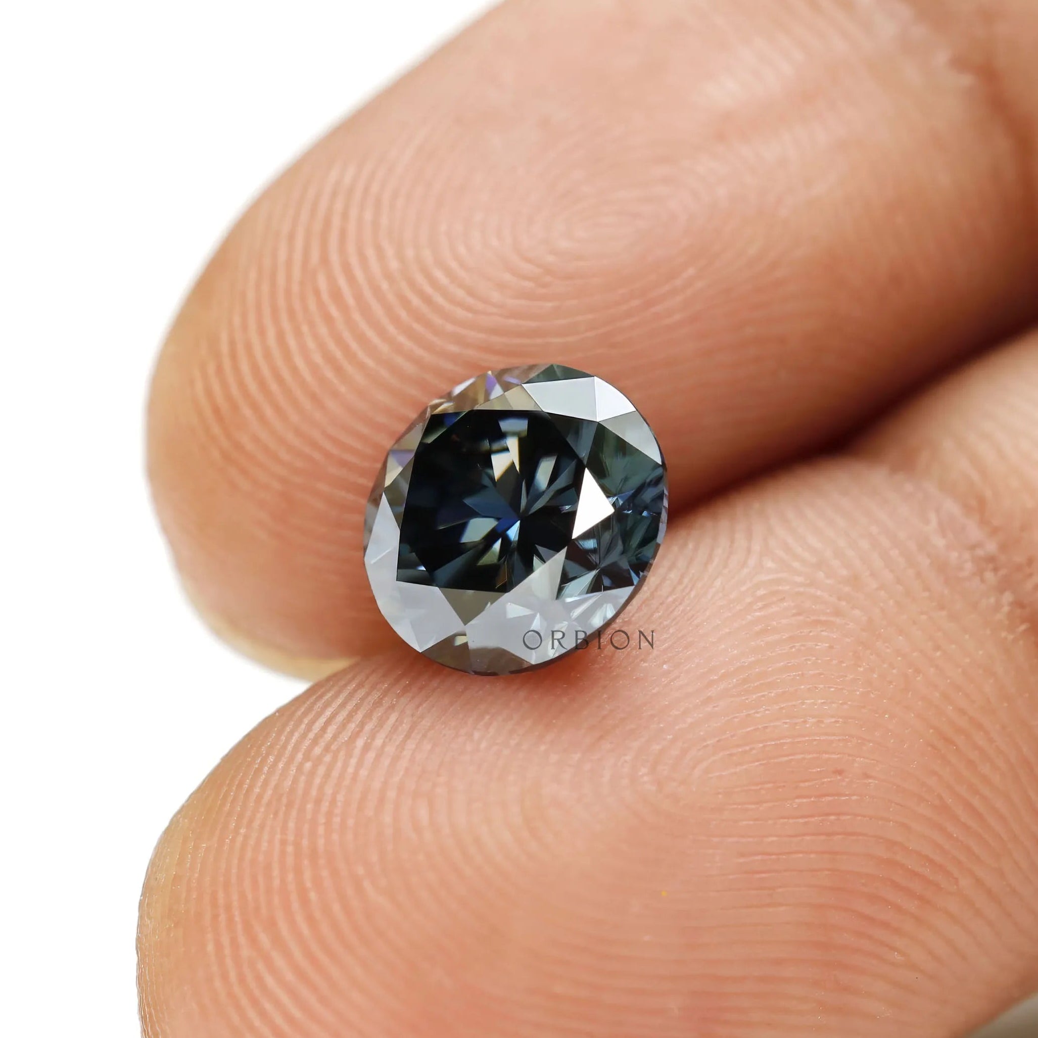 Detailed view of dark grey moissanite round stone with symmetrical facets