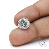 Loose round moissanite held by hand