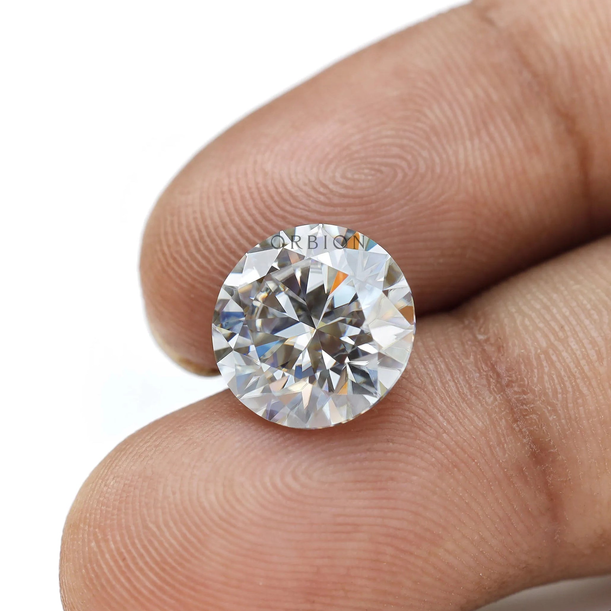 Loose round moissanite held by hand