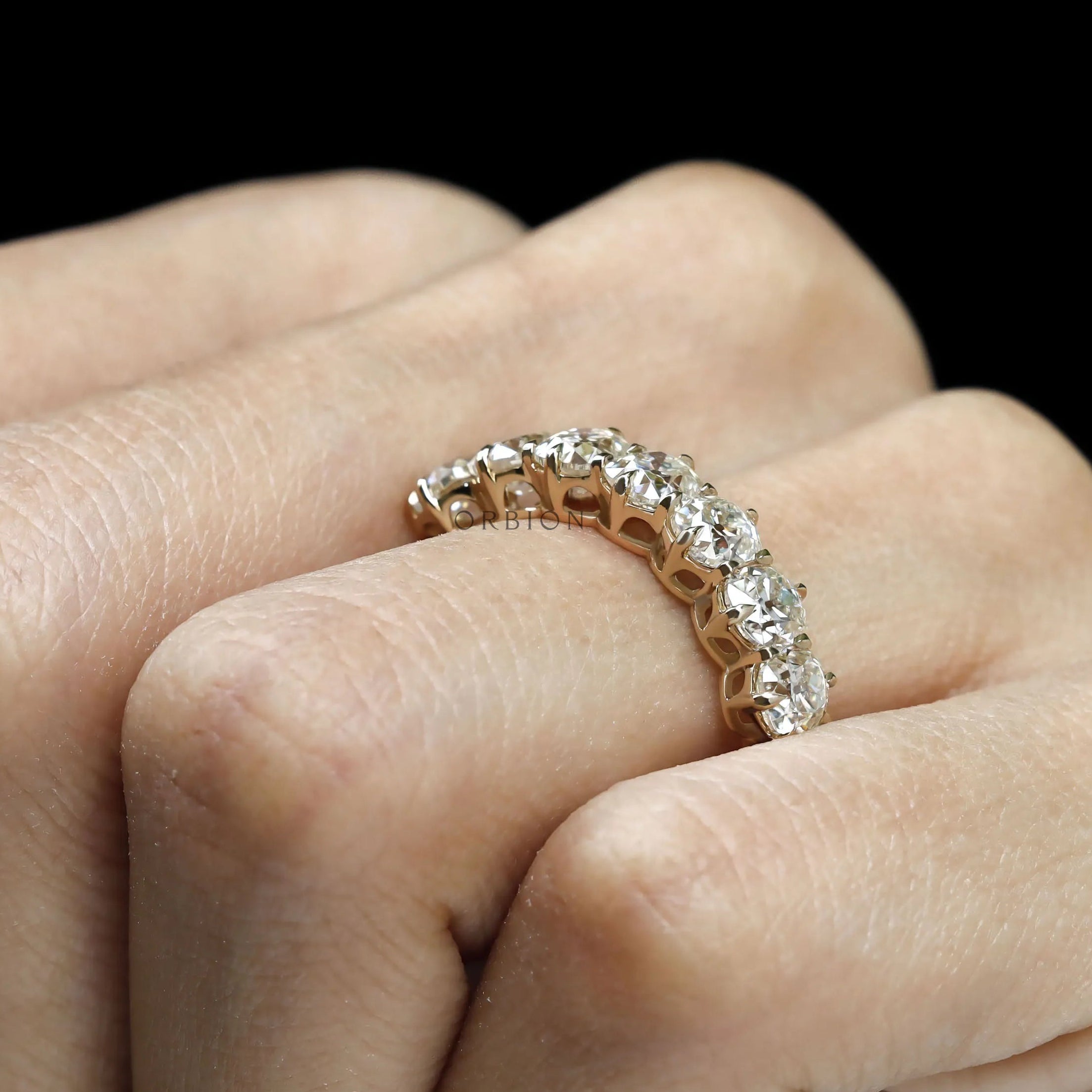 Old mine cut seven stone cushion moissanite wedding band in yellow gold, half eternity design