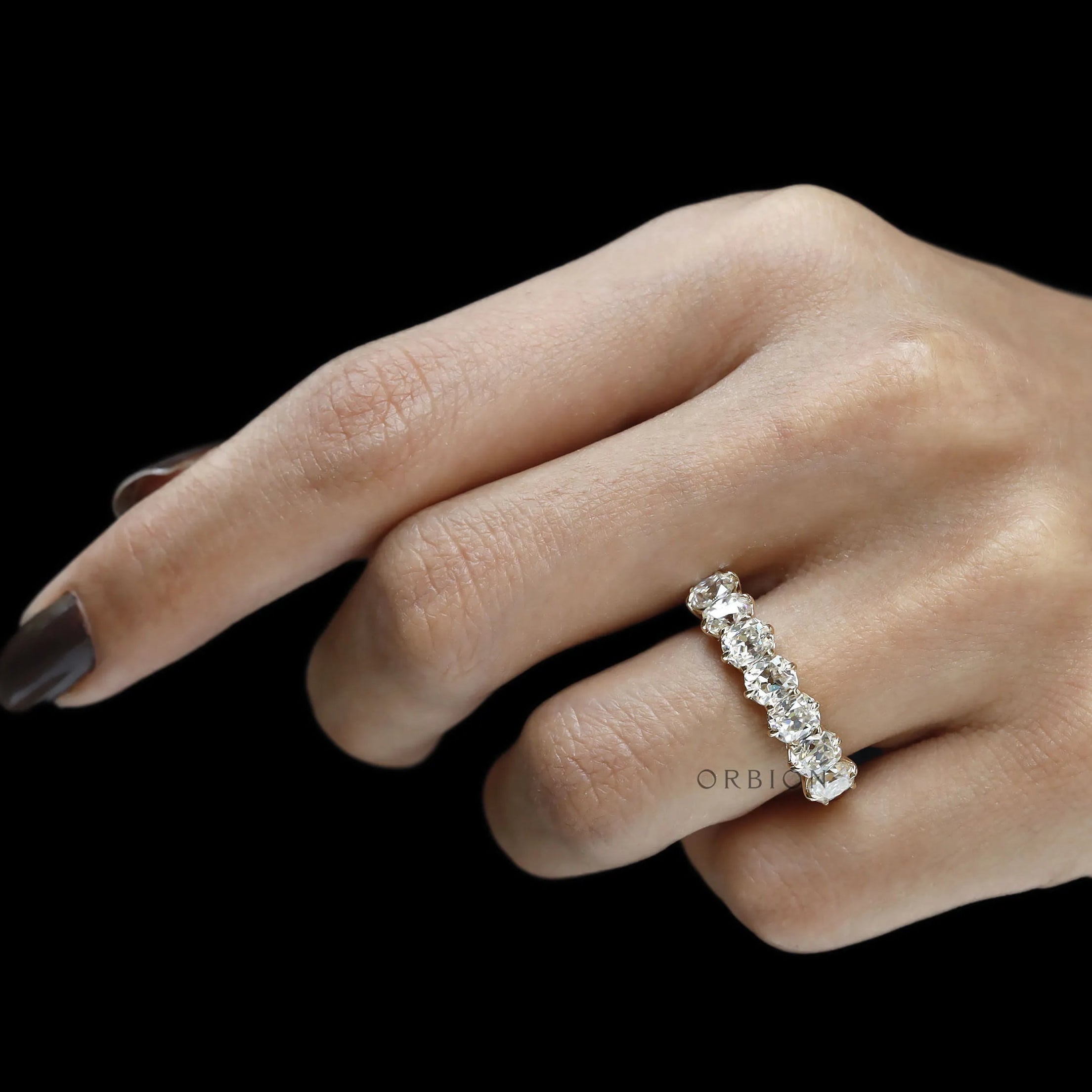 Yellow gold half eternity wedding band with seven cushion moissanite stones, old mine cut