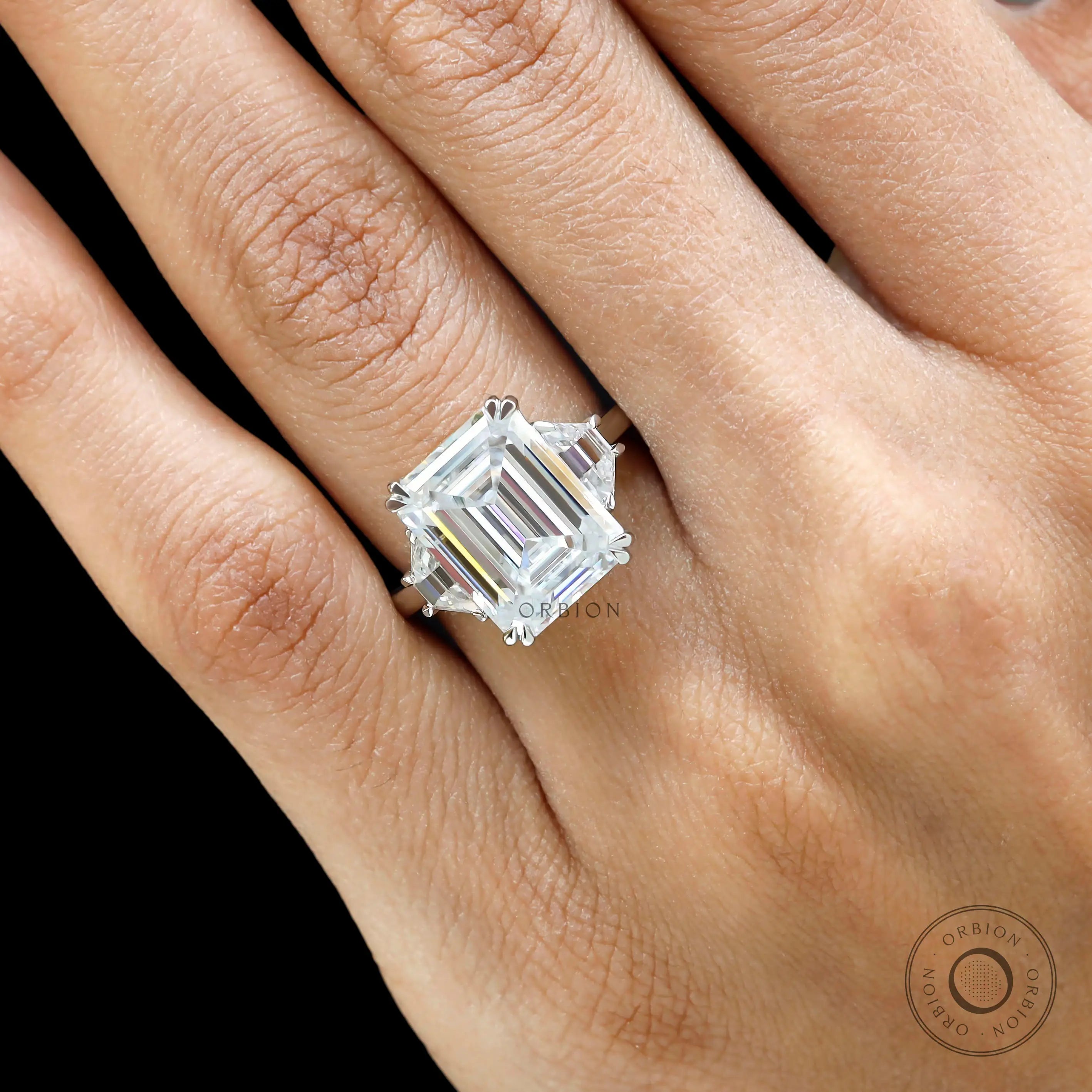 Platinum emerald cut trilogy engagement ring with trapezoid side stones