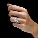 Emerald cut solitaire style trilogy ring with trapezoid step cut side stones