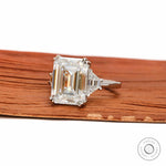 Close up emerald cut step cut center stone with trapezoid side stones