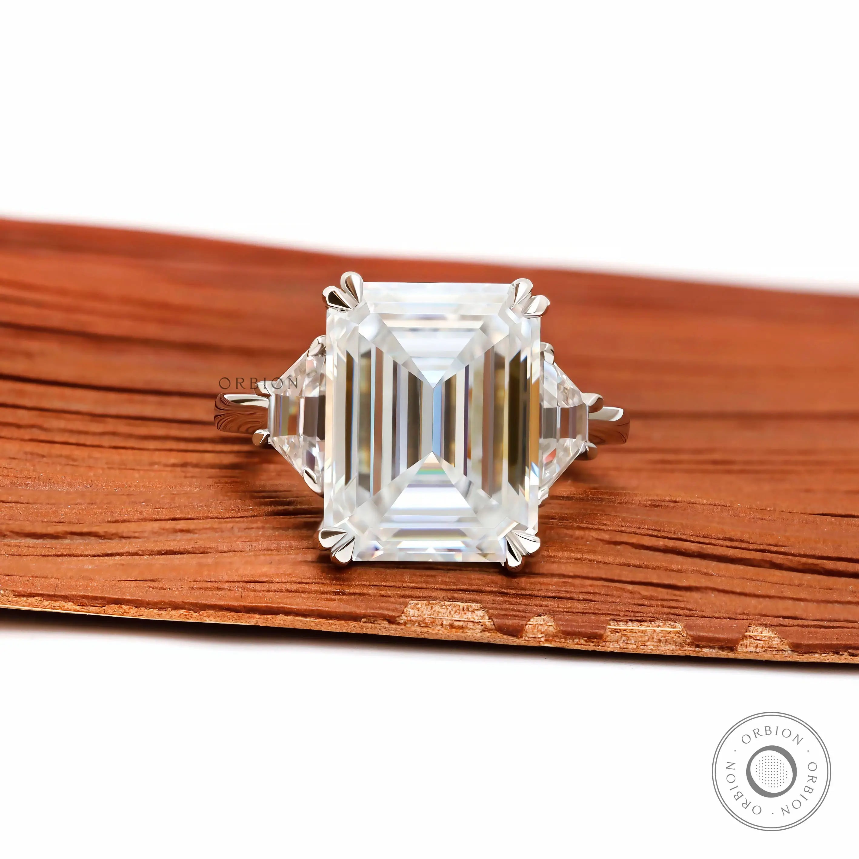 Emerald cut three stone engagement ring with trapezoid side stones in platinum