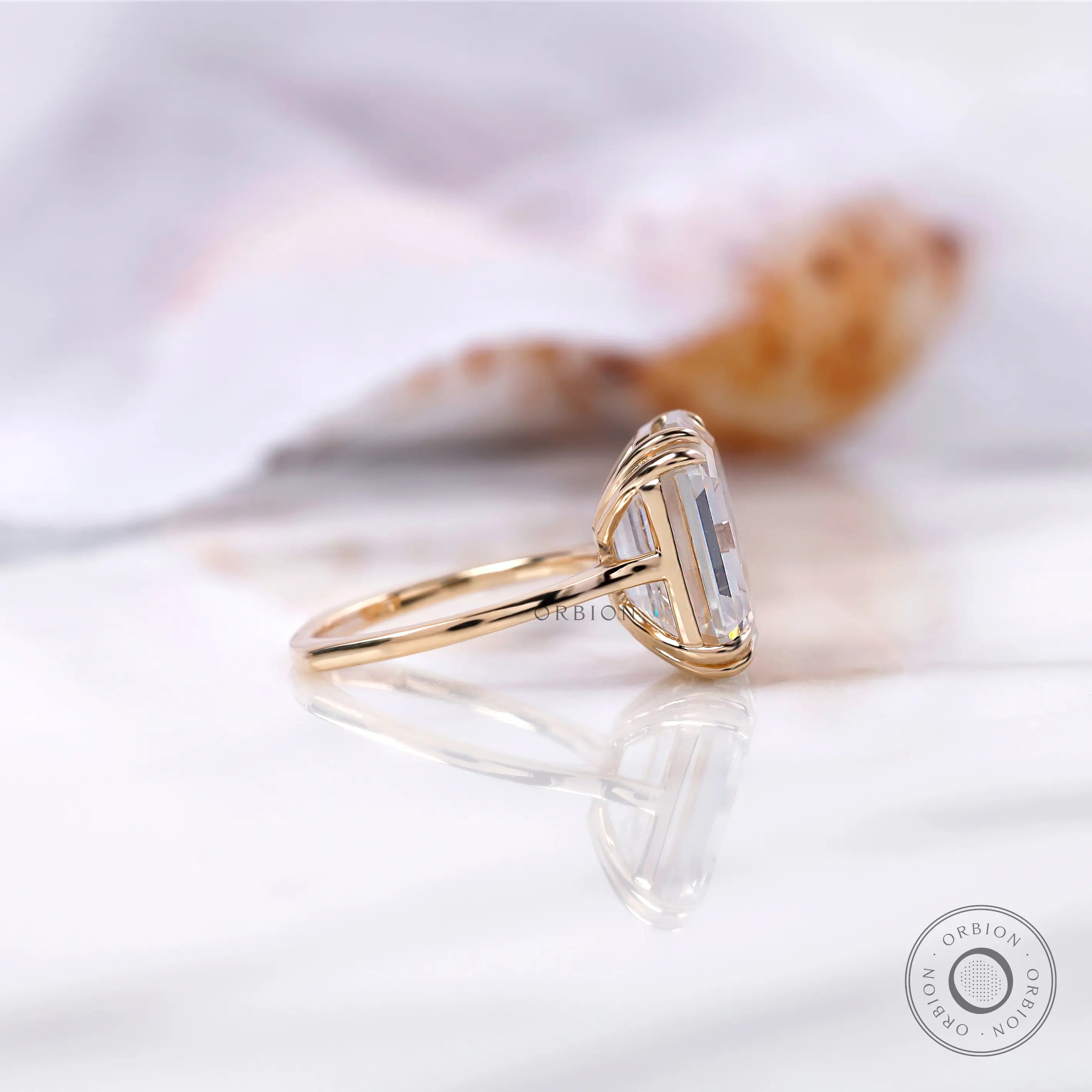 Side view of emerald cut two piece ring set in yellow gold