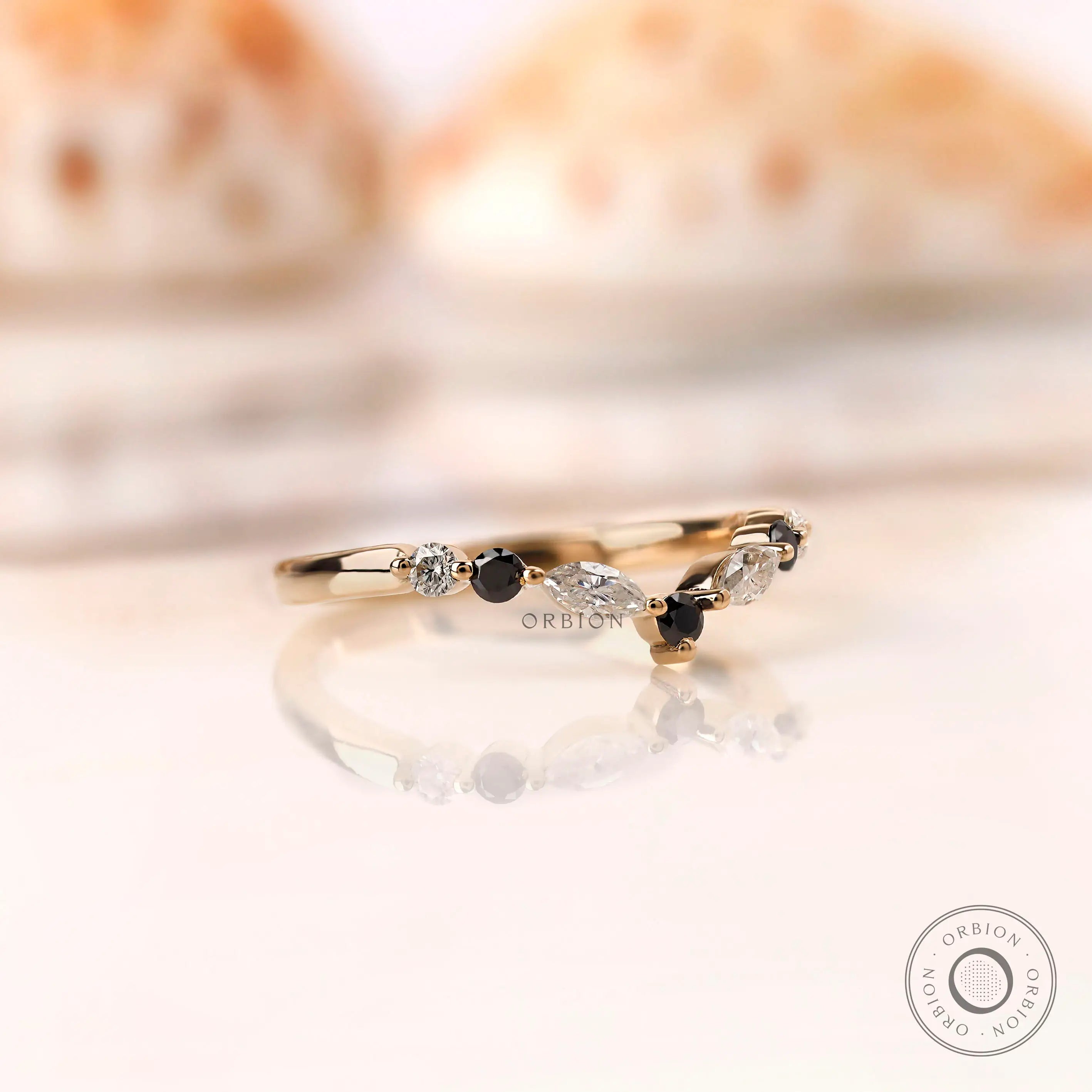 Angled view showing marquise and round moissanite on chevron ring