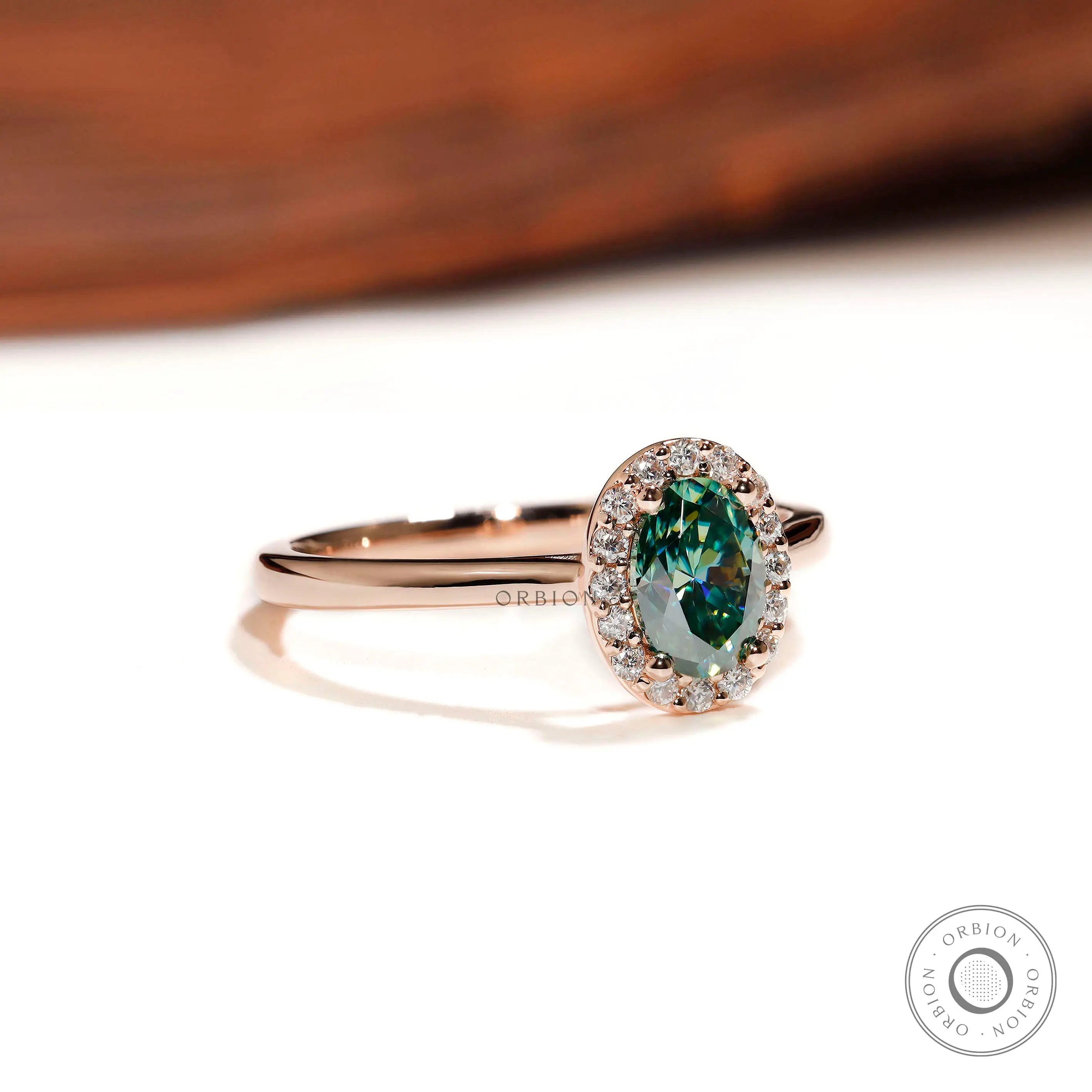 Side profile of oval halo blue green moissanite ring in rose gold