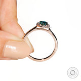 Oval blue green moissanite ring with halo front cathedral view