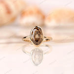 Dark champagne oval Old Mine Cut moissanite bezel set ring in 14K yellow gold front view