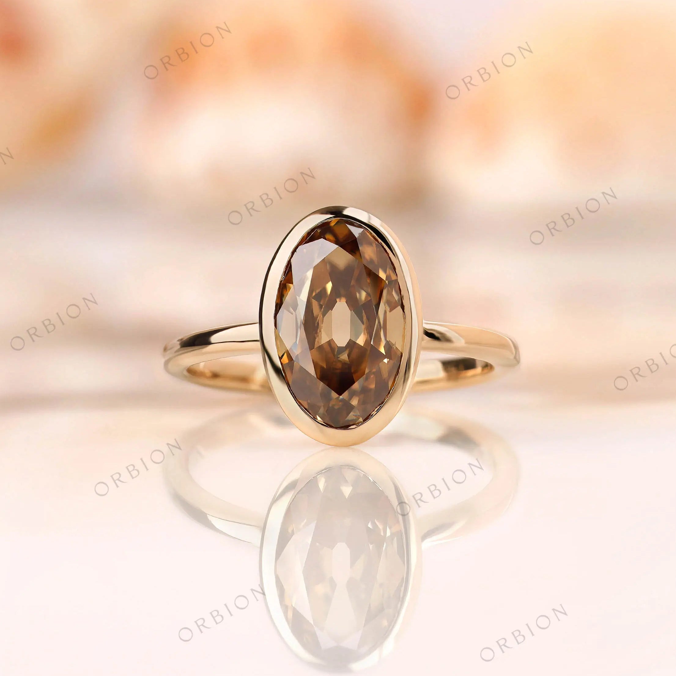 Dark champagne oval Old Mine Cut moissanite bezel set ring in 14K yellow gold front view