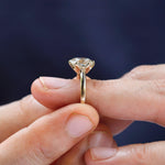 Elongated cushion moissanite solitaire ring worn on finger