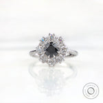 Front view vintage cluster halo ring with black moissanite center stone.
