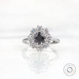 Front view vintage cluster halo ring with black moissanite center stone.