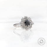 Angled front view showing black center with bright moissanite halo cluster.