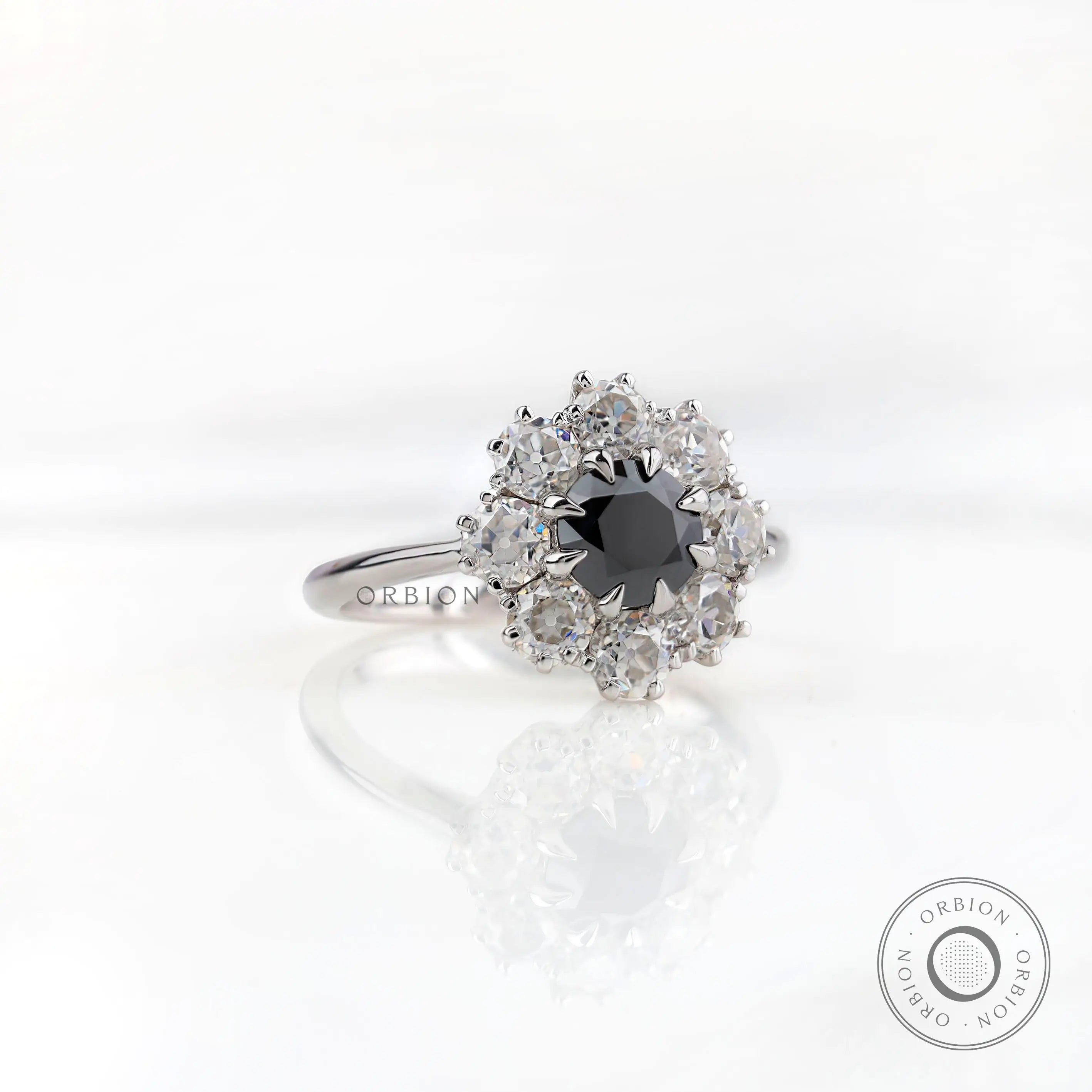 Angled front view showing black center with bright moissanite halo cluster.