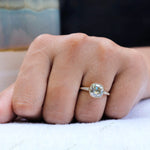 Profile view of Bezel Set Cushion Cut Moissanite Engagement Ring on a finger with delicate side stone detailing