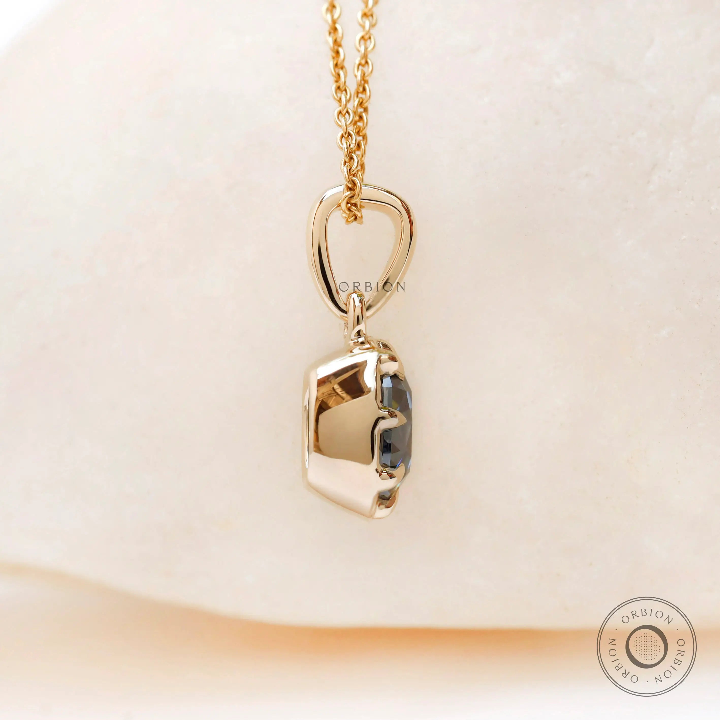 Angled view cushion moissanite pendant in yellow gold bezel