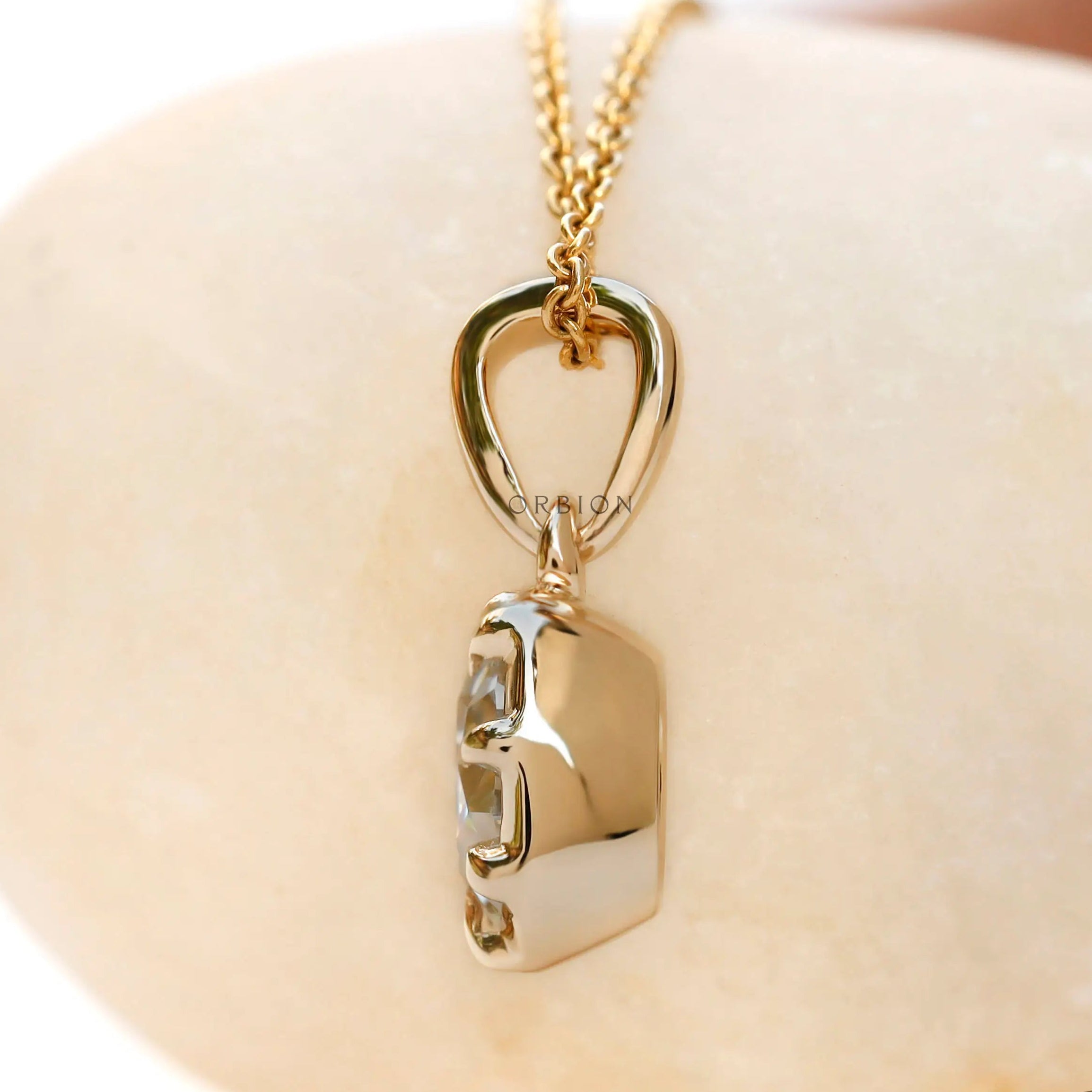 Angled view cushion moissanite pendant in yellow gold bezel