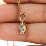 Angled hand view cushion moissanite pendant in yellow gold bezel