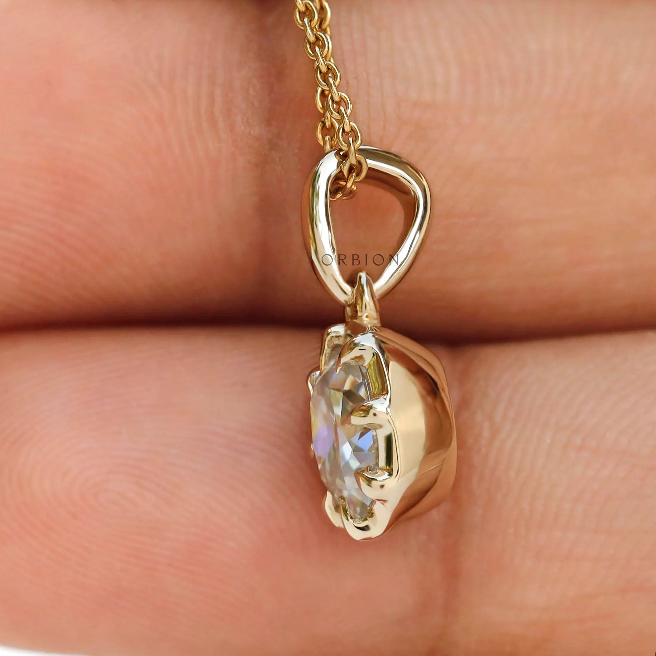 Angled hand view cushion moissanite pendant in yellow gold bezel