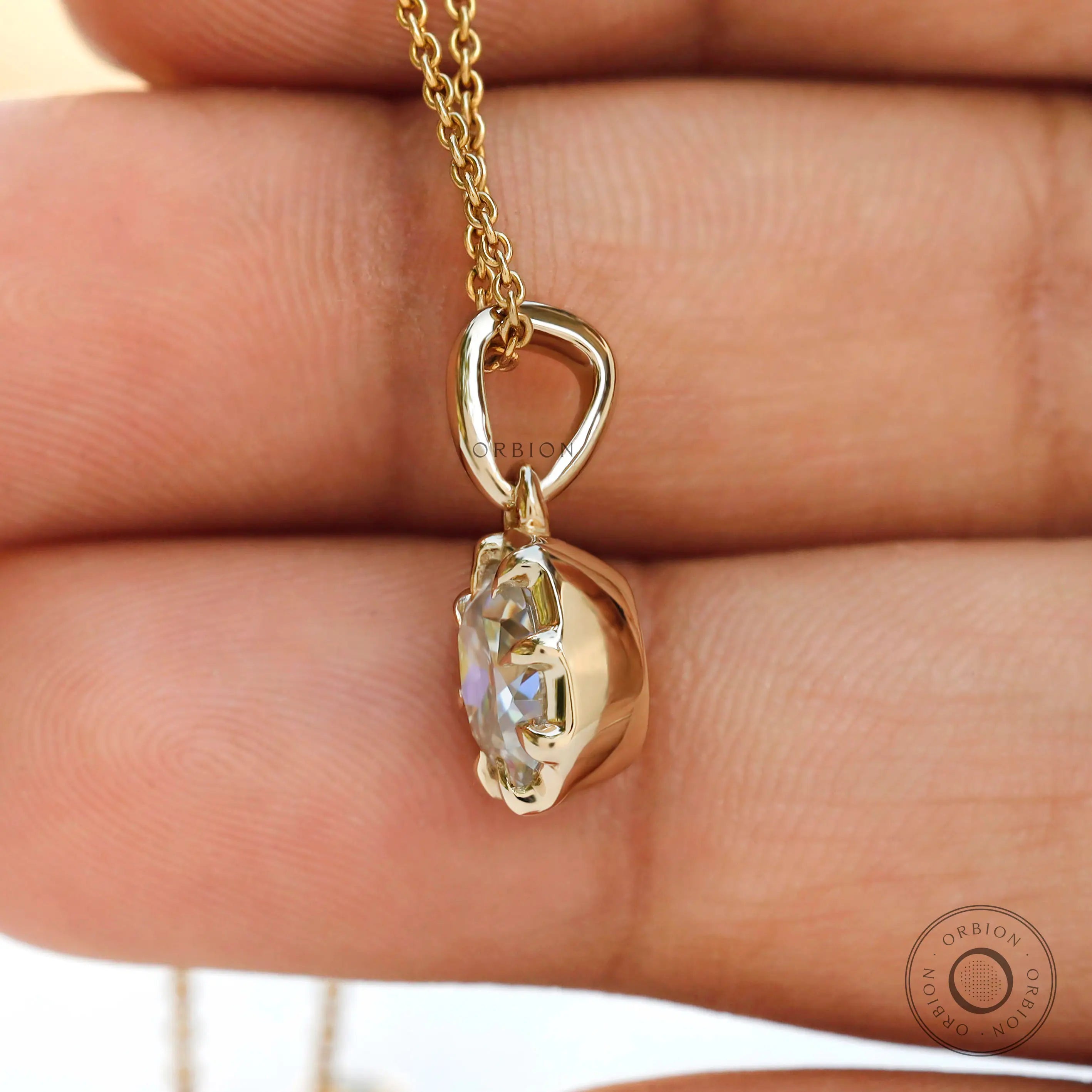 Angled hand view cushion moissanite pendant in yellow gold bezel