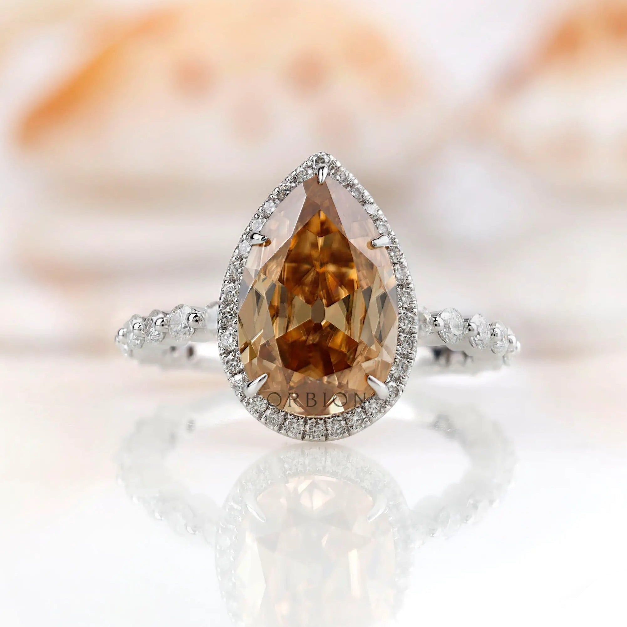 Pear Moissanite Old Mine Cut halo ring with round side stones in 14K white gold