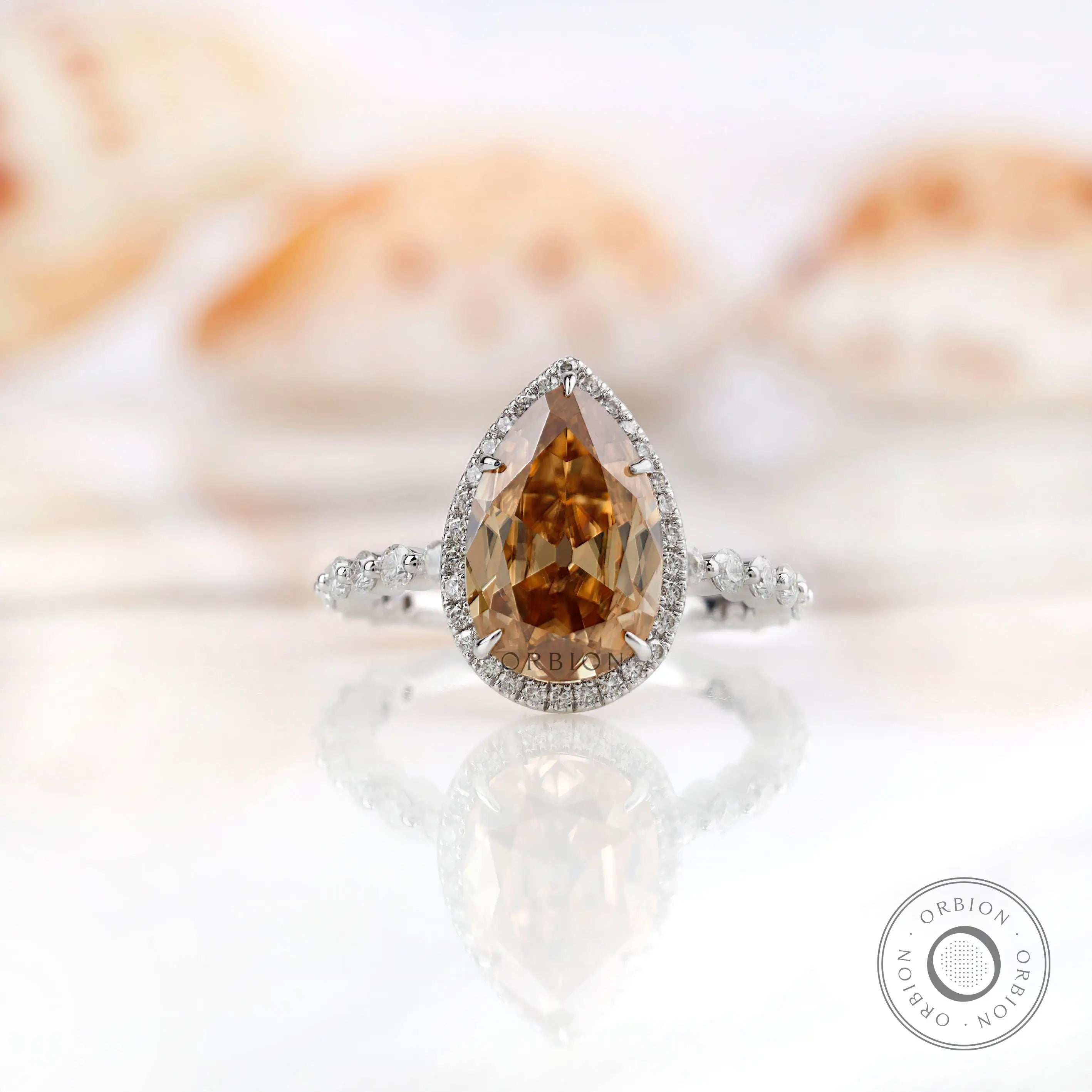 Pear Moissanite Old Mine Cut halo ring with round side stones in 14K white gold
