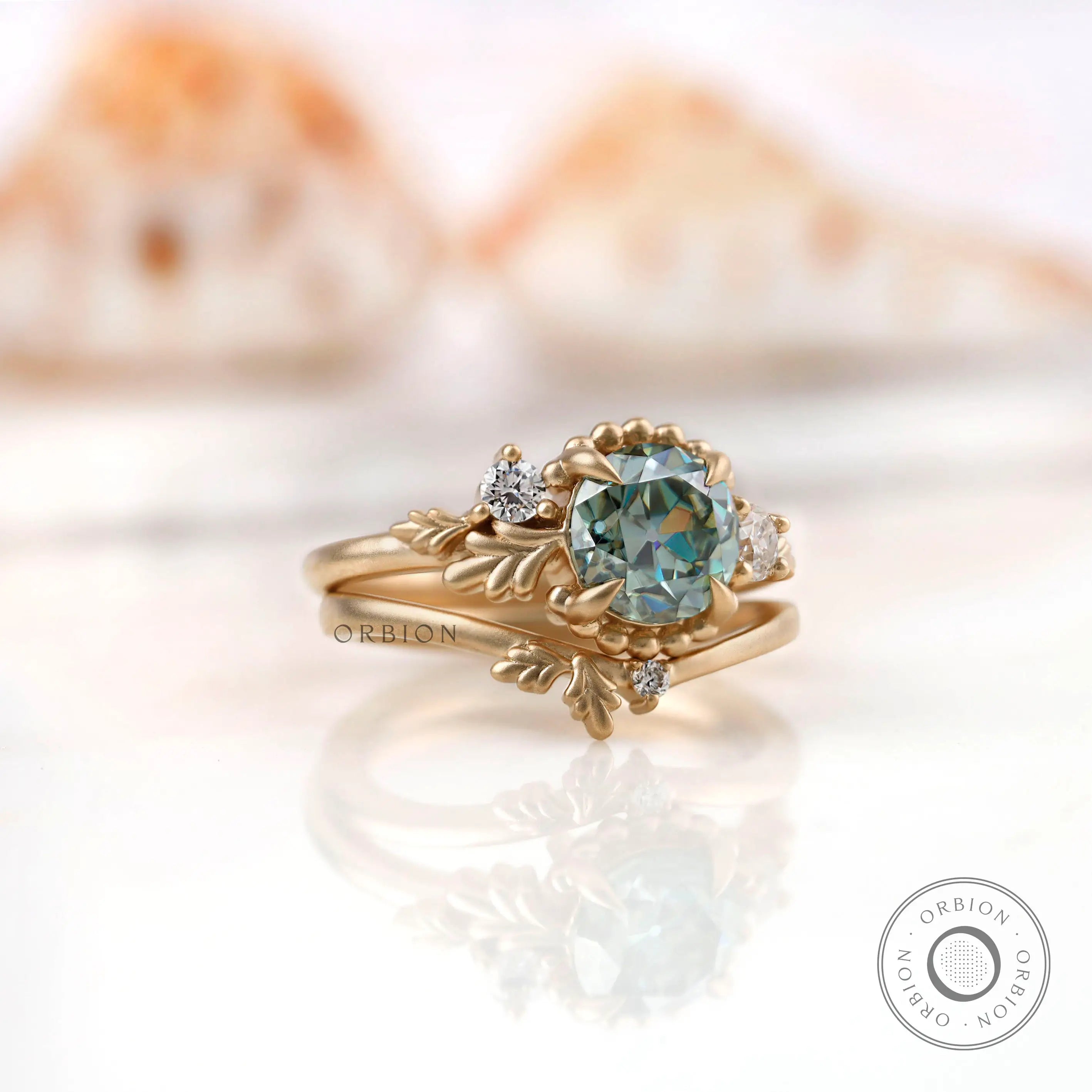 Angled view of OEC Moissanite ring set with leaf motif in gold.