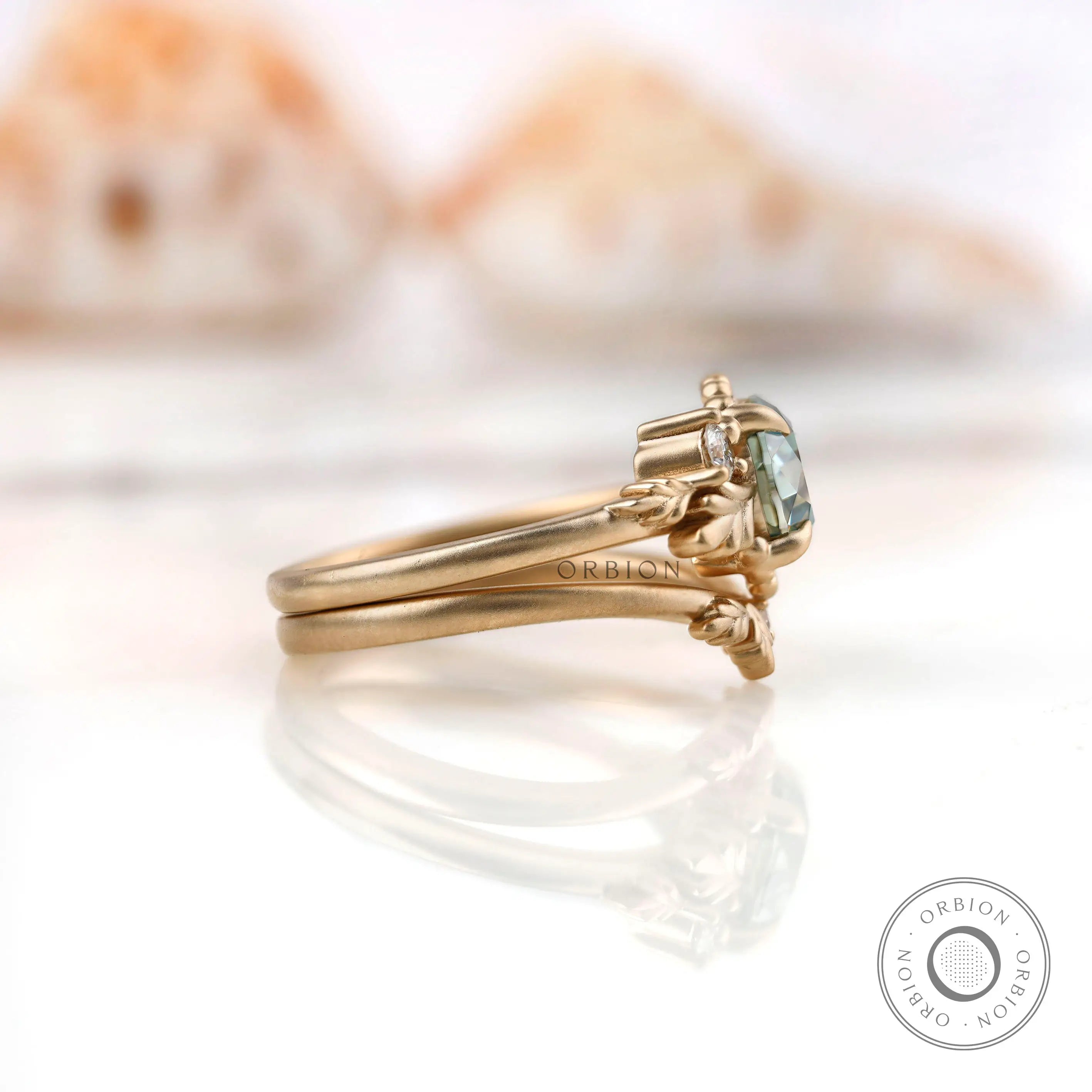 Side view showing intricate leaf motif setting with OEC Moissanite.