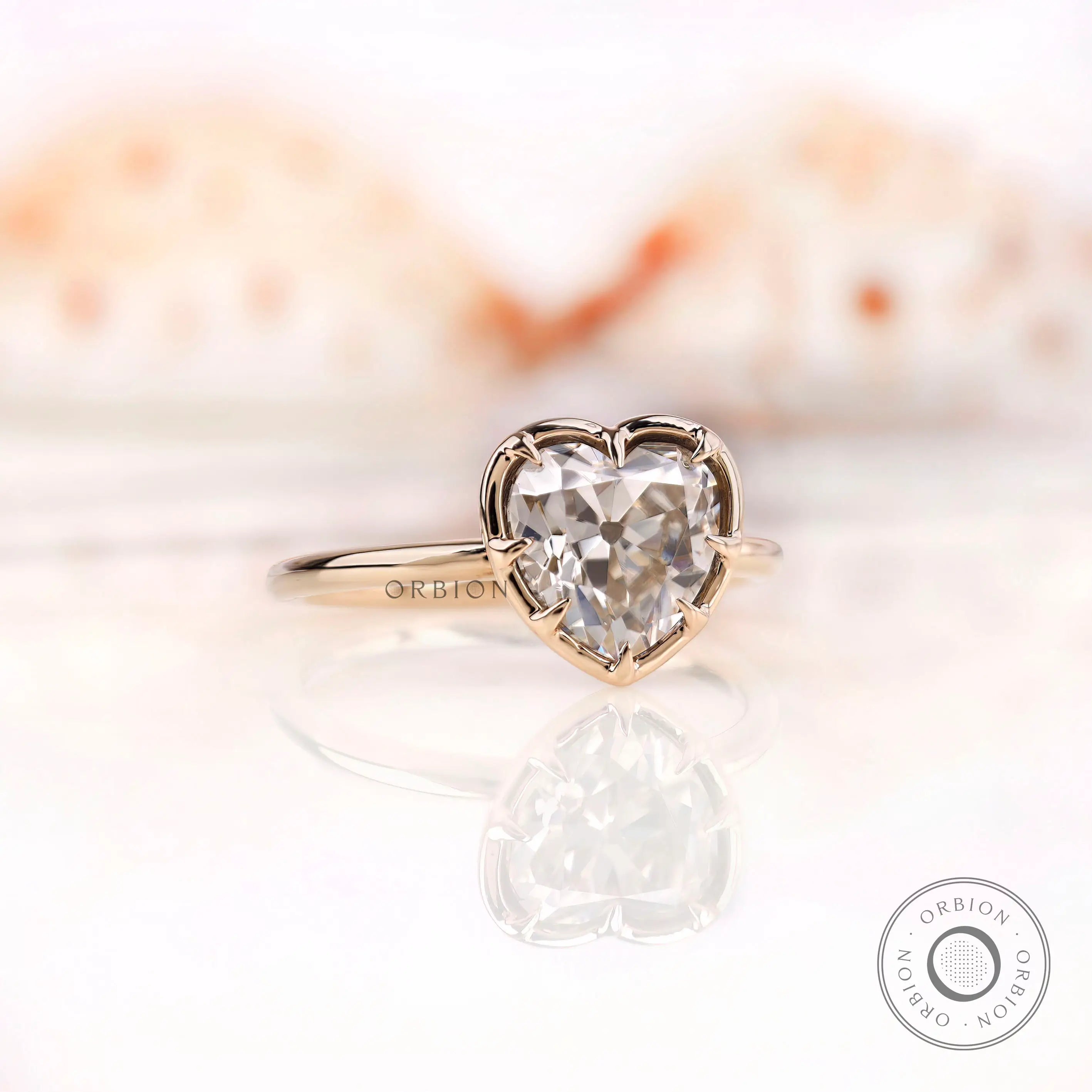Angled view showing heart moissanite and prong setting