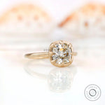 Angled side view of the square cushion GHI moissanite solitaire bezel set engagement ring in yellow gold.