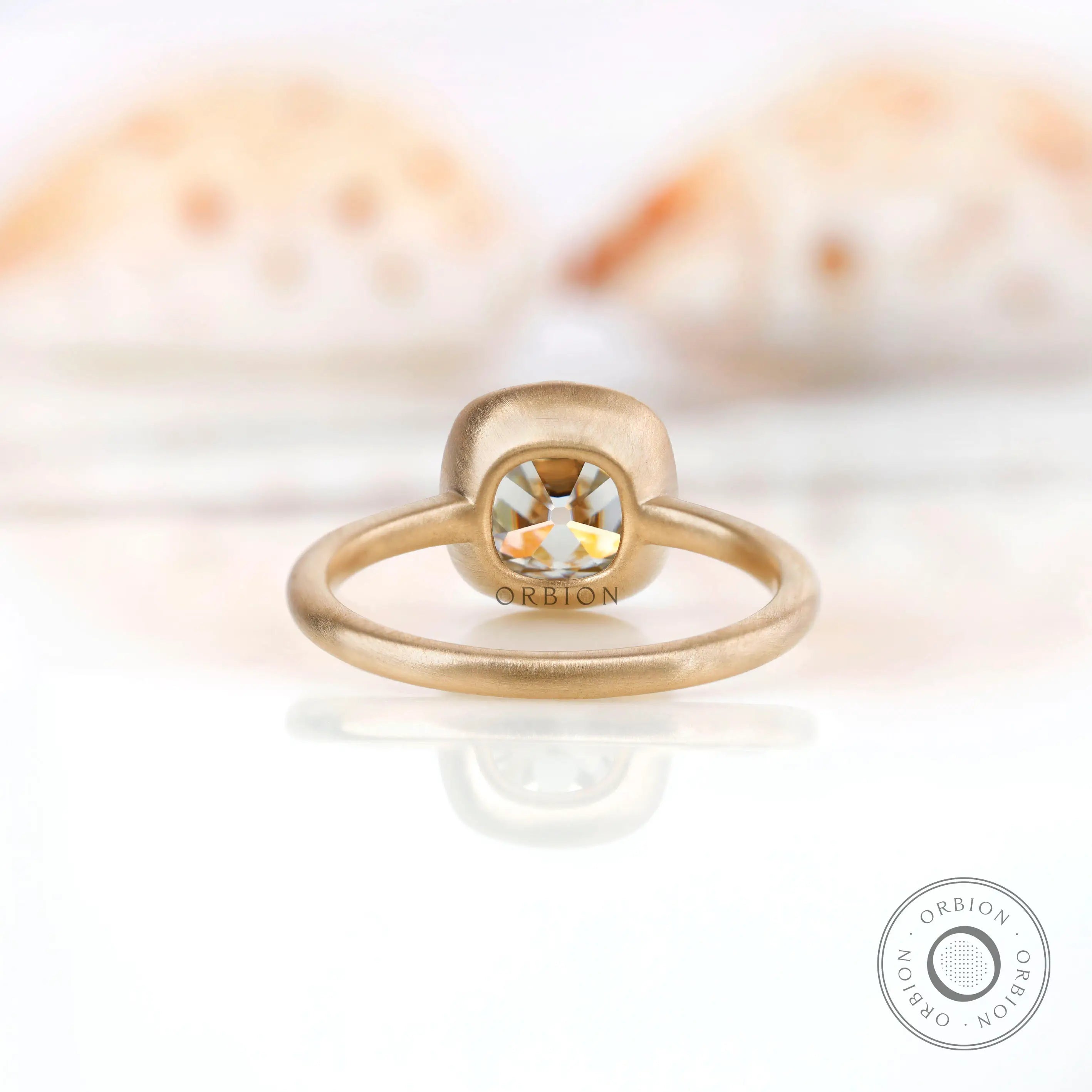 Back view of the square cushion GHI moissanite solitaire bezel set engagement ring in 10K yellow gold.